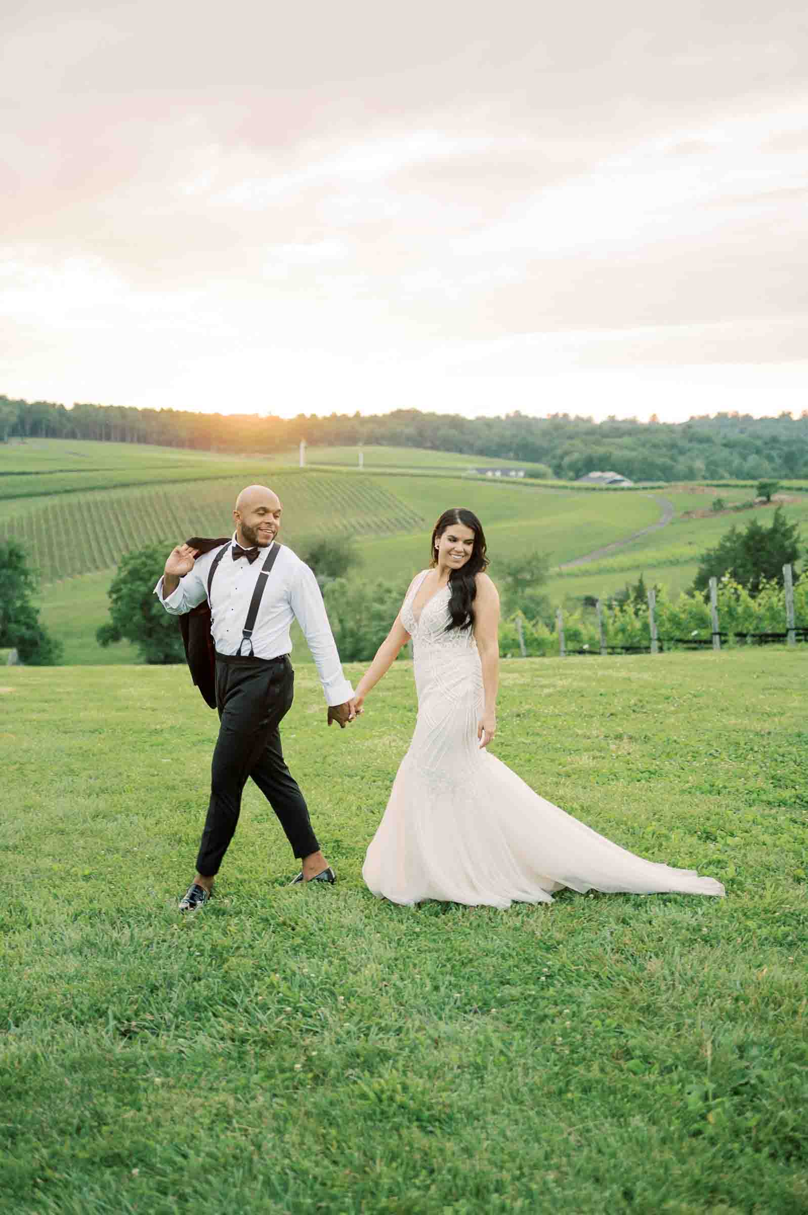 bride and groom walking through the vines at stone tower winery during sunset in leesburg virginia